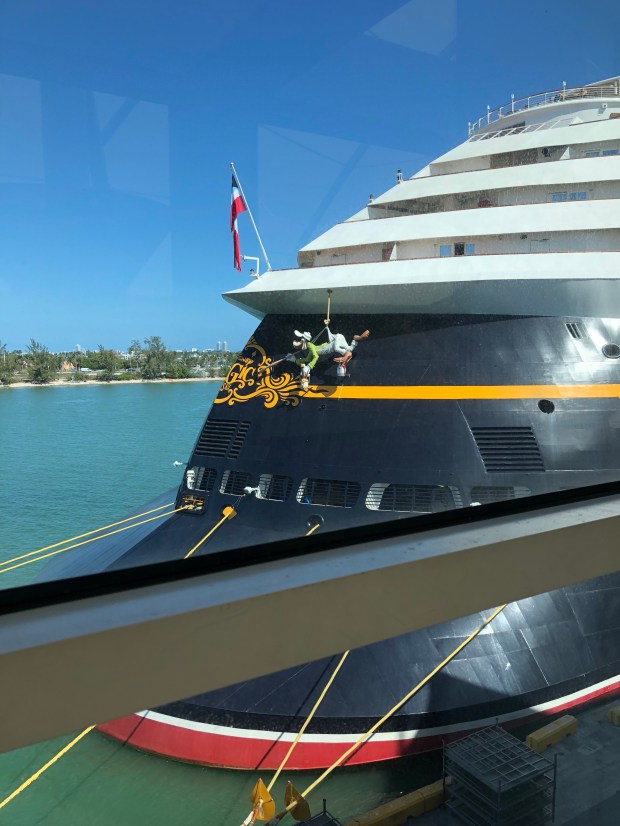Goofy painting the exterior of the Disney Magic